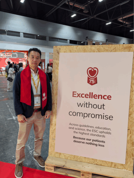 Dr. Joshua Loh standing with a sign with Excellence without Compromise written at the ESC Congress 2025